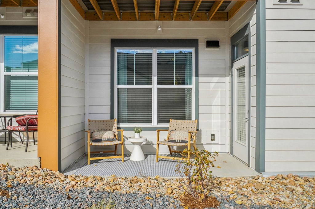 a front porch with two chairs and a toilet on it at Premier at West Park Luxury Apartment Homes, Greeley, CO, 80634