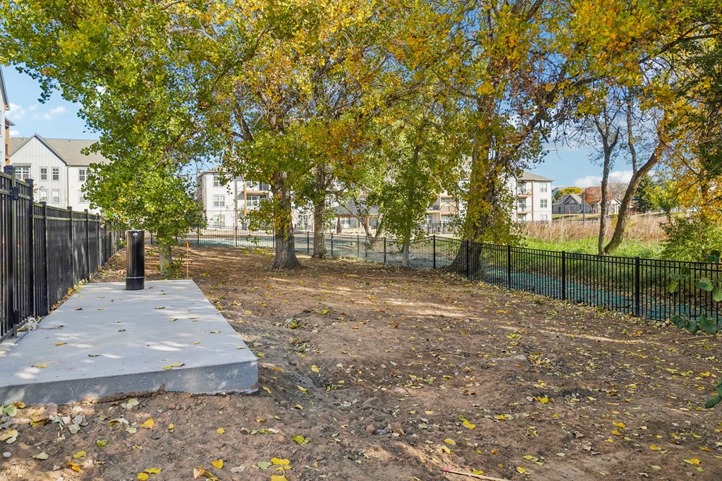 a park with trees and a concrete slab in front of a fence at Premier at West Park Luxury Apartment Homes, Greeley, 80634