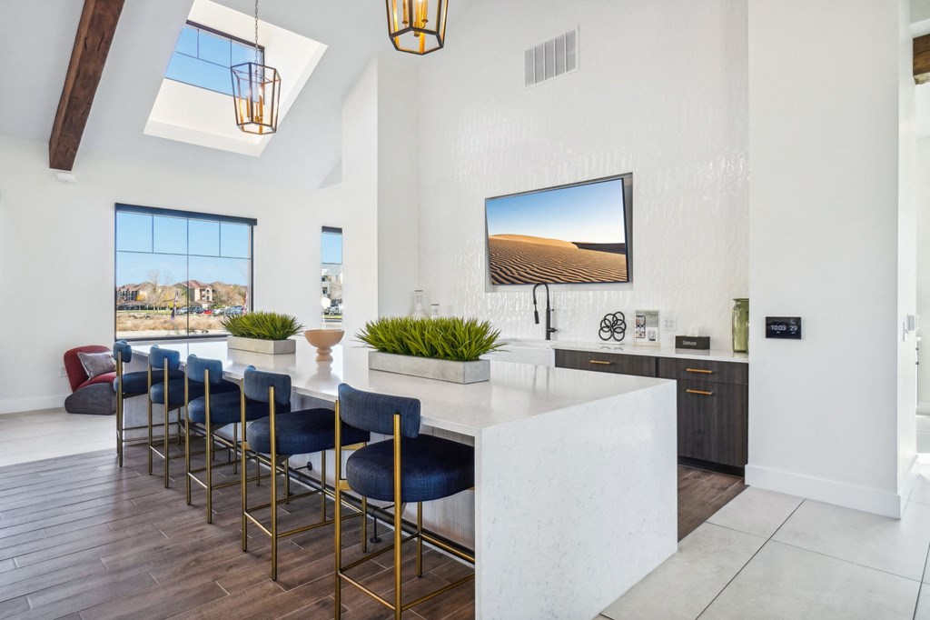 a kitchen with a marble counter top and blue bar stools at Premier at West Park Luxury Apartment Homes, Greeley, CO, 80634