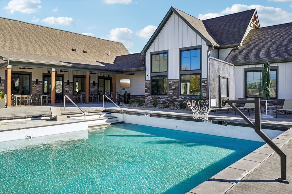 a swimming pool in front of a house at Premier at West Park Luxury Apartment Homes, Greeley, CO, 80634