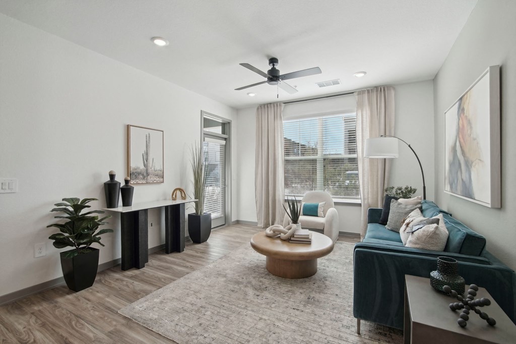 a living room with a couch and a ceiling fan at The Maddox Luxury Apartment Homes, Arizona, 85326