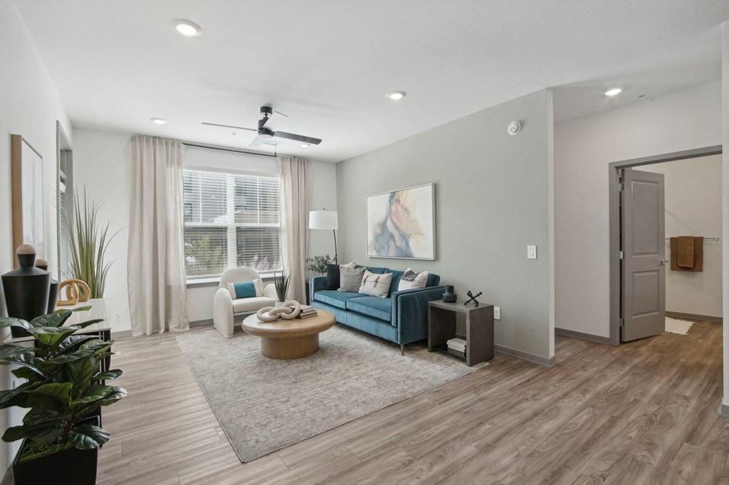 a living room with a couch and a coffee table in front of a window at The Maddox Luxury Apartment Homes, Buckeye, AZ