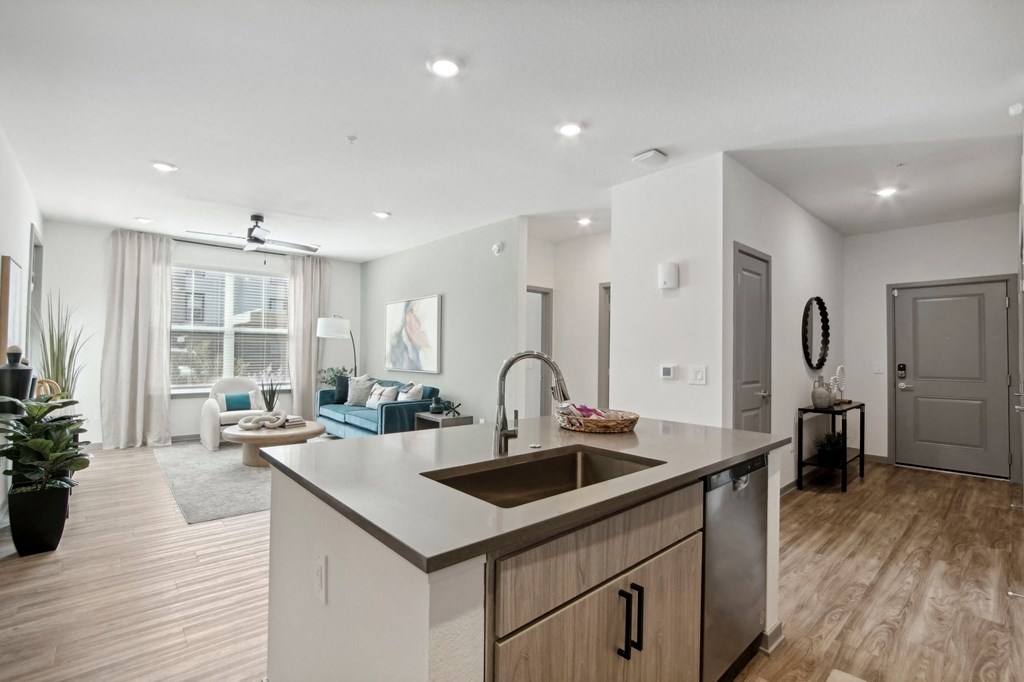 an open kitchen and living room with a large window and a sink at The Maddox Luxury Apartment Homes, Buckeye, AZ