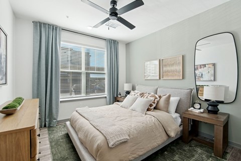 a bedroom with a large bed and a ceiling fan at The Maddox Luxury Apartment Homes, Arizona