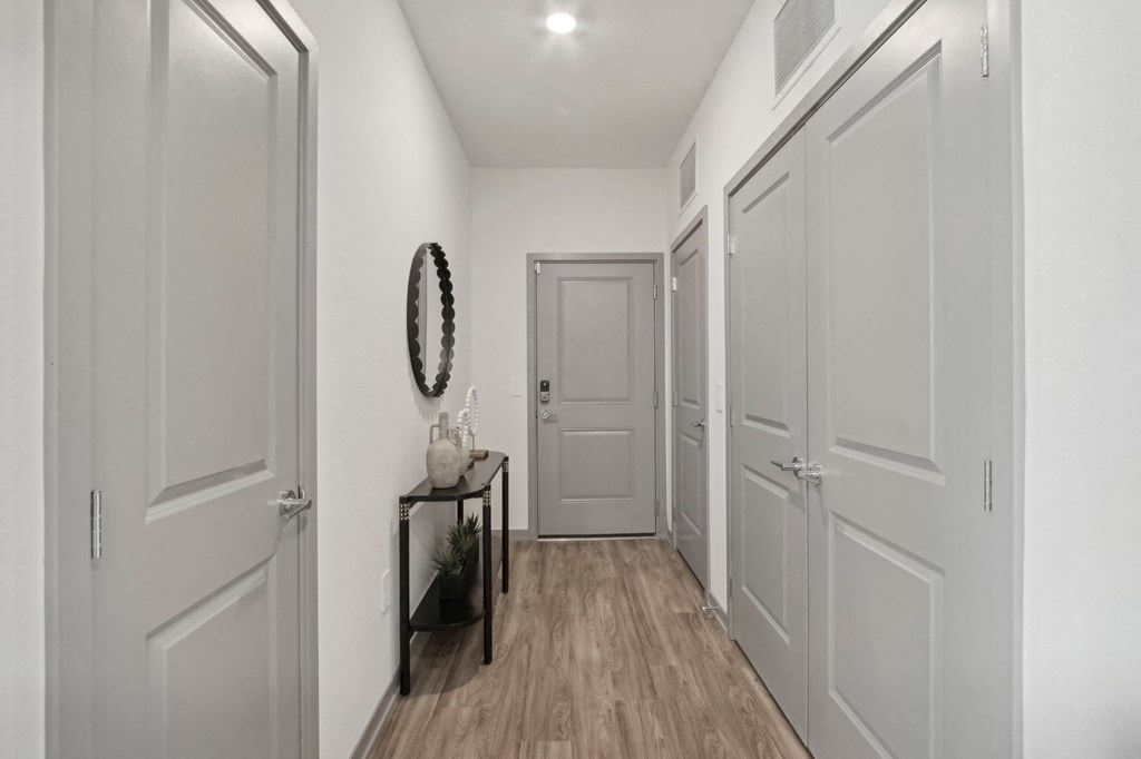 a hallway with white walls and white doors and a door to a closet at The Maddox Luxury Apartment Homes, Arizona