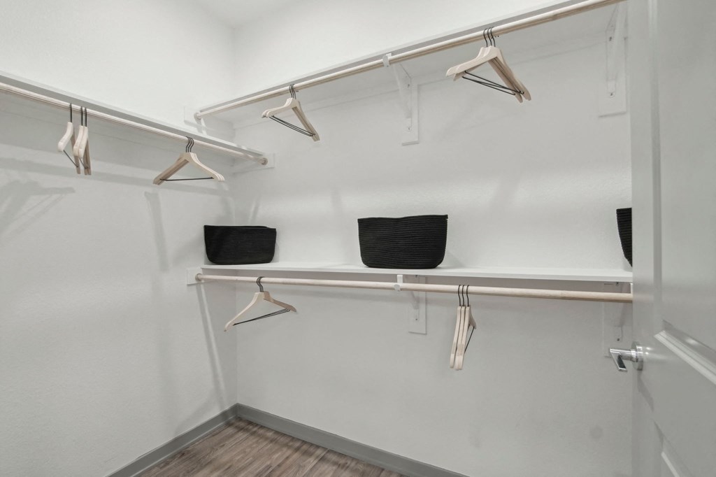 a walk in closet with shelves and hangers on the wall at The Maddox Luxury Apartment Homes, Buckeye