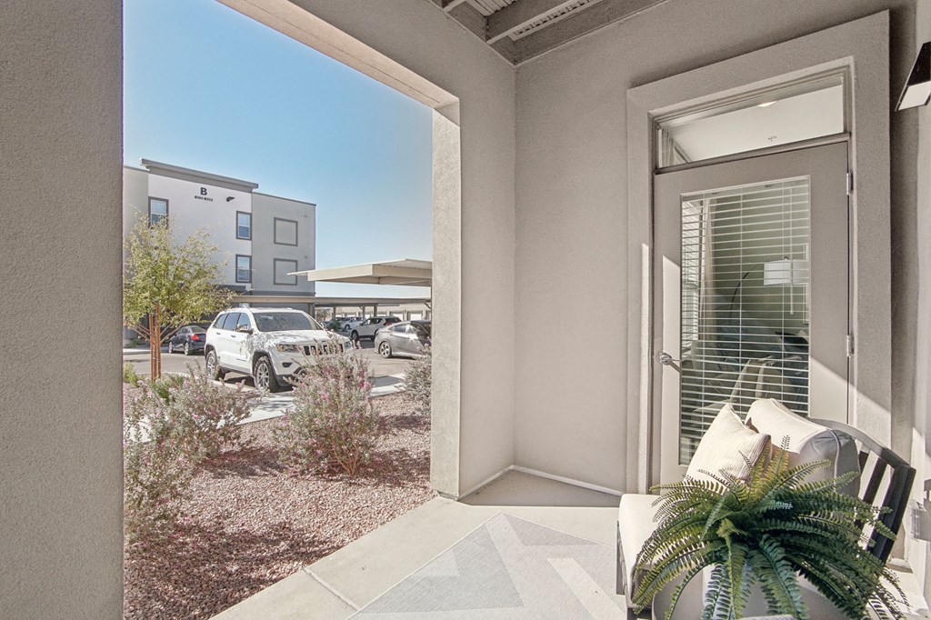 a patio with a chair and a door to a parking lot at The Maddox Luxury Apartment Homes, Arizona, 85326