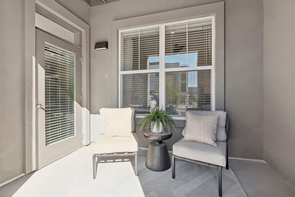 a living room with a couch and a table and a window at The Maddox Luxury Apartment Homes, Buckeye, AZ 85326