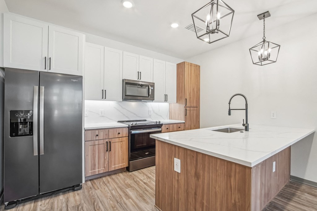 a kitchen with a large island and stainless steel refrigerator at The Maddox Luxury Apartment Homes, Arizona, 85326