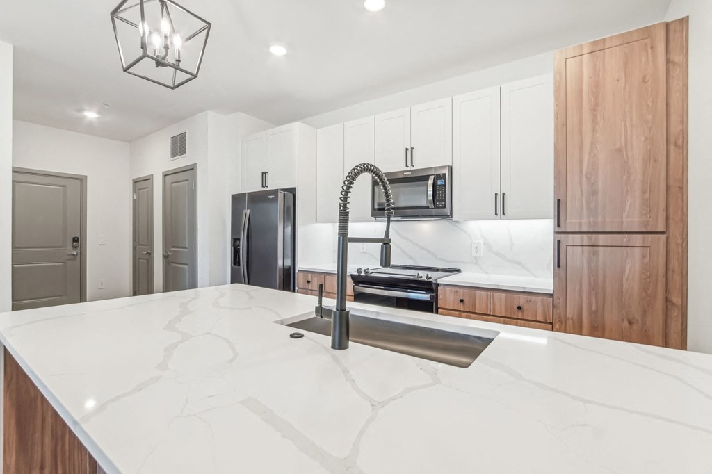 a large kitchen with white counter tops and a sink at The Maddox Luxury Apartment Homes, Buckeye Arizona