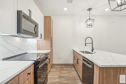 A kitchen with a white counter top and wooden cabinets.