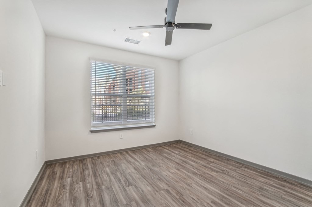 an empty living room with a ceiling fan and a window at The Maddox Luxury Apartment Homes, Buckeye, AZ 85326