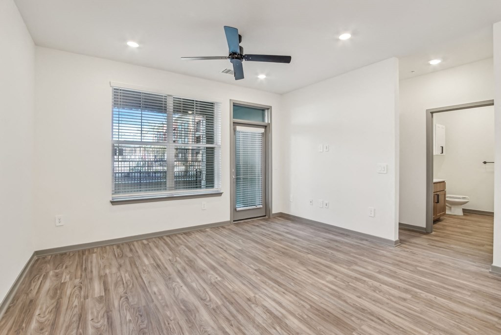 an empty living room with a large window and a ceiling fan at The Maddox Luxury Apartment Homes, Buckeye