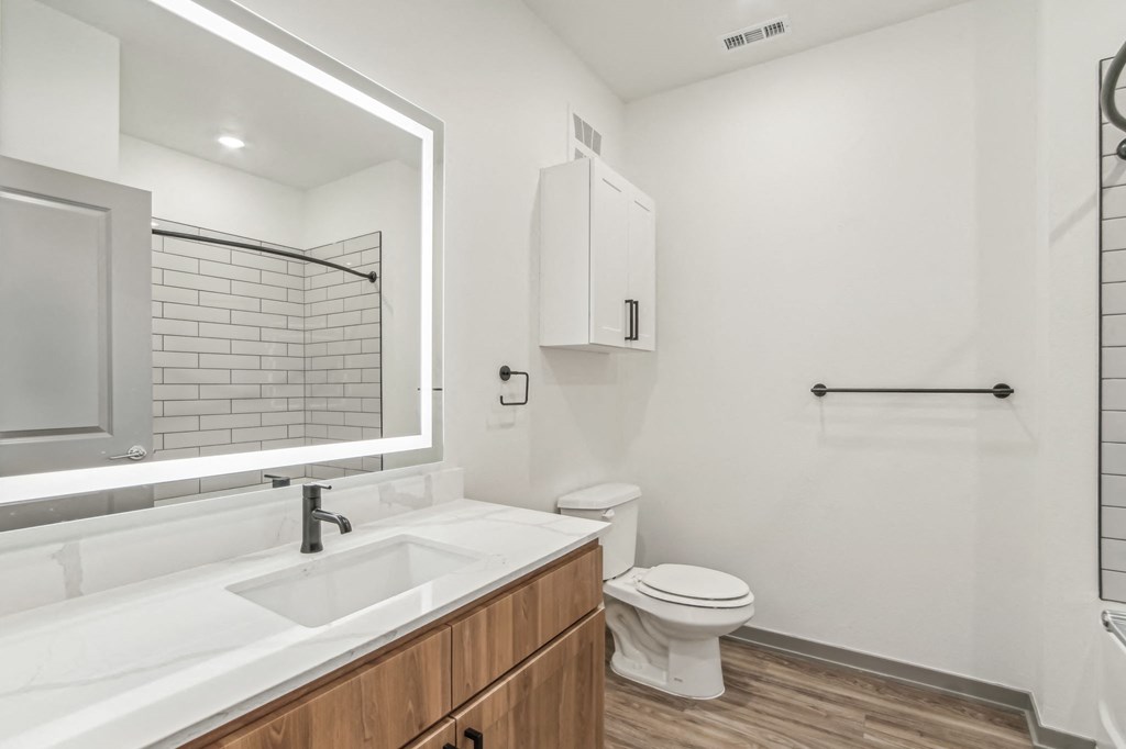 a bathroom with a sink and a toilet and a mirror at The Maddox Luxury Apartment Homes, Arizona