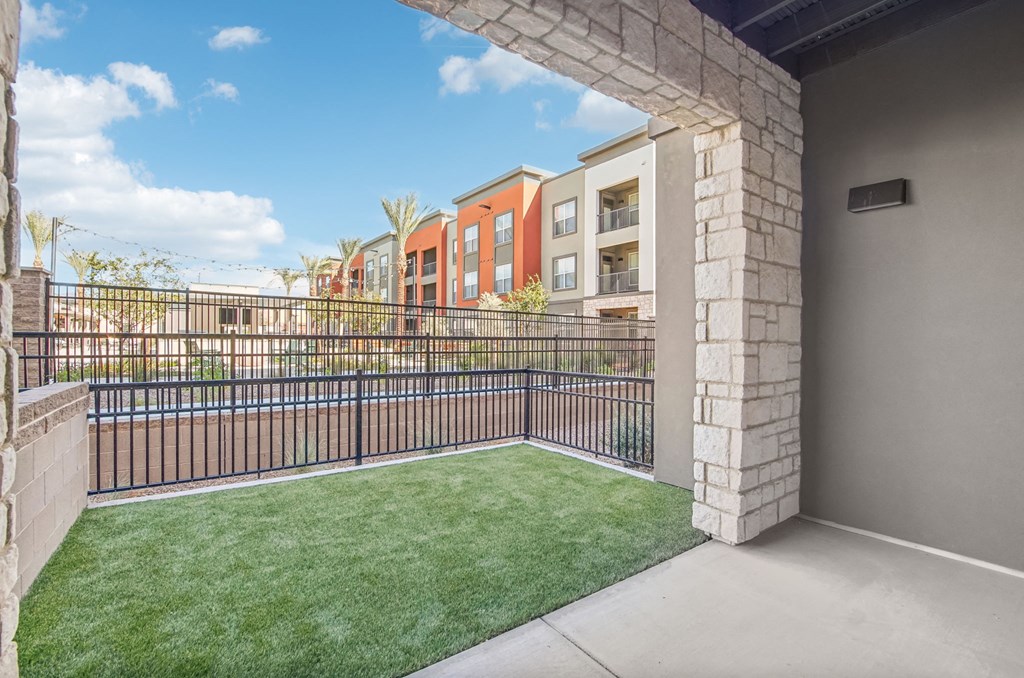 our apartments have a spacious balcony with grass and a fence at The Maddox Luxury Apartment Homes, Buckeye Arizona