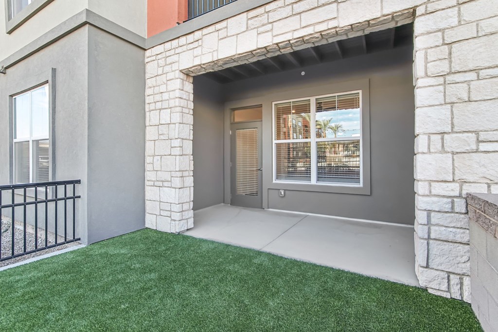 a rendering of the front porch of a house with green grass at The Maddox Luxury Apartment Homes, Buckeye, 85326