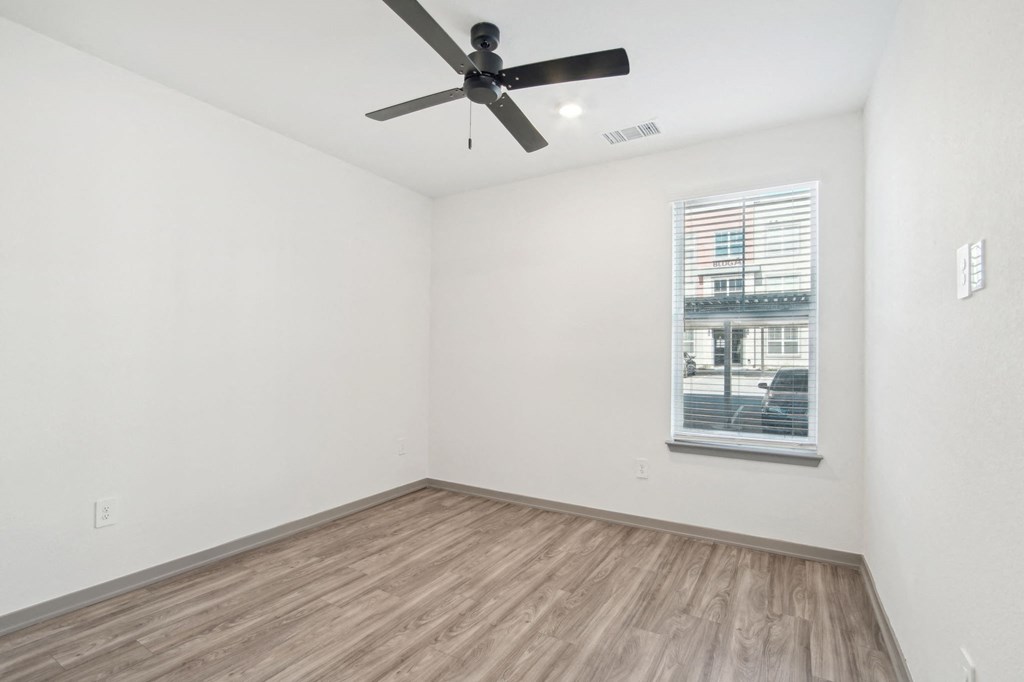 an empty room with a ceiling fan and a window at The Maddox Luxury Apartment Homes, Buckeye