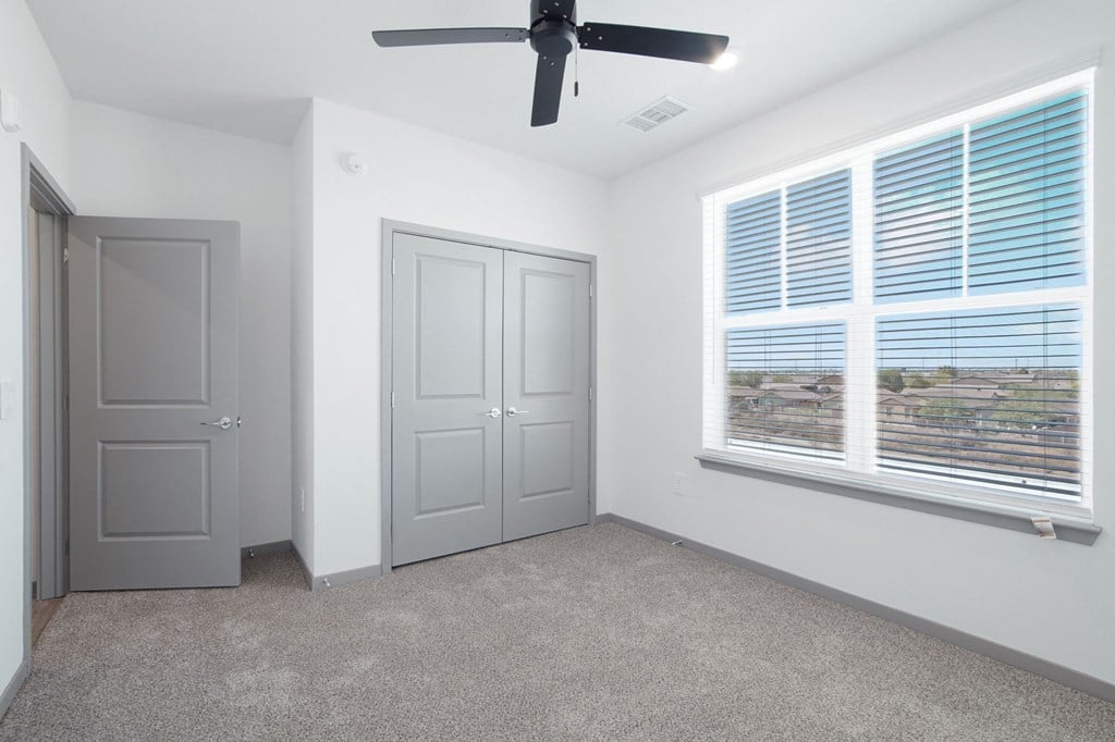 an empty room with a large window and a ceiling fan at The Maddox Luxury Apartment Homes, Buckeye, AZ 85326