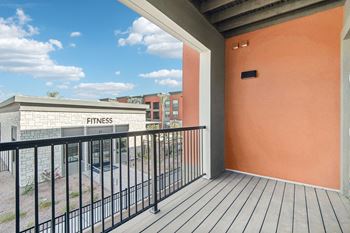 a balcony with a view of a fitness center and a building at The Maddox Luxury Apartment Homes, Buckeye, AZ, 85326
