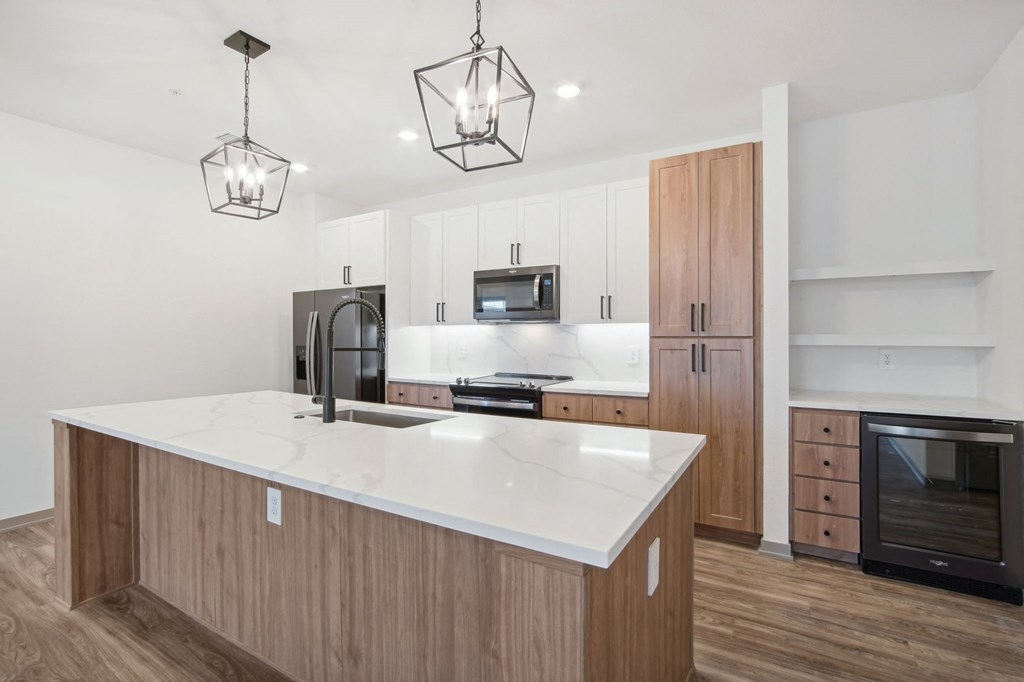 a white kitchen with wooden cabinets and a white counter top at The Maddox Luxury Apartment Homes, Buckeye, 85326