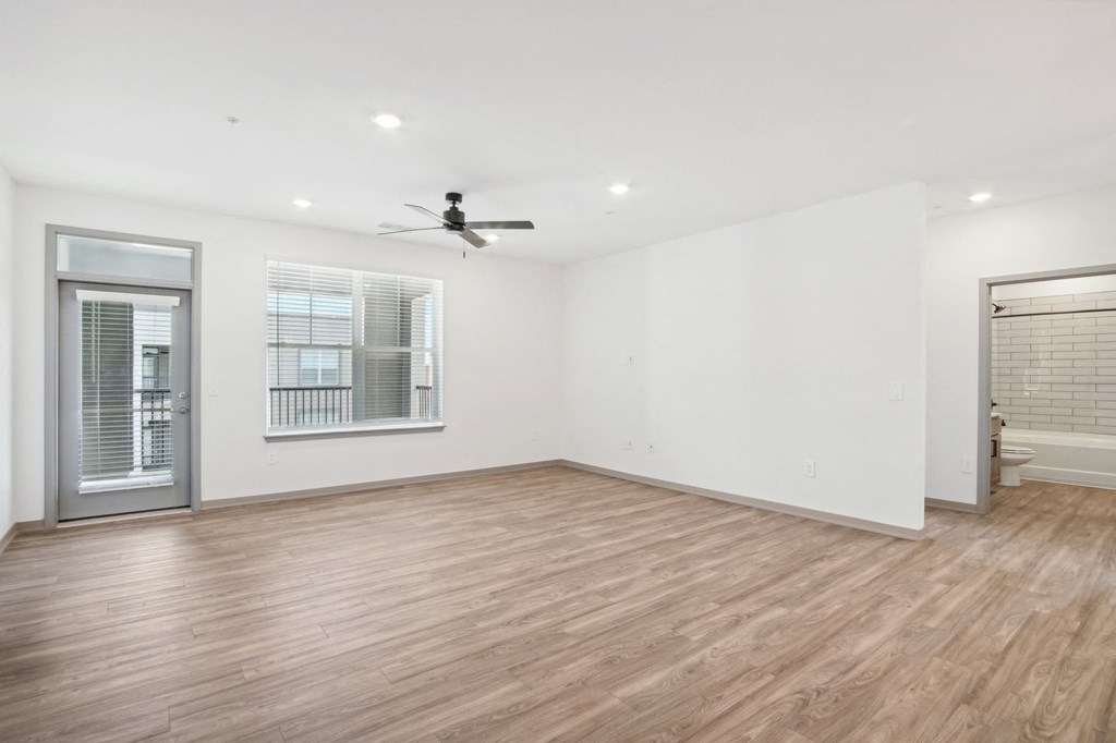 an empty living room with white walls and a ceiling fan at The Maddox Luxury Apartment Homes, Buckeye, AZ