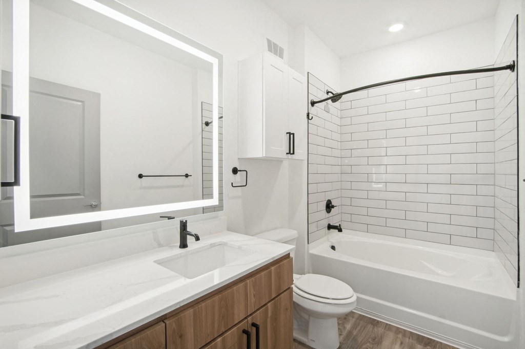 a white bathroom with a tub and a toilet and a sink at The Maddox Luxury Apartment Homes, Arizona