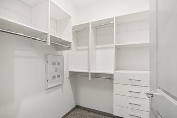 a walk in closet with white walls and white drawers and at The Maddox Luxury Apartment Homes, Buckeye, Arizona