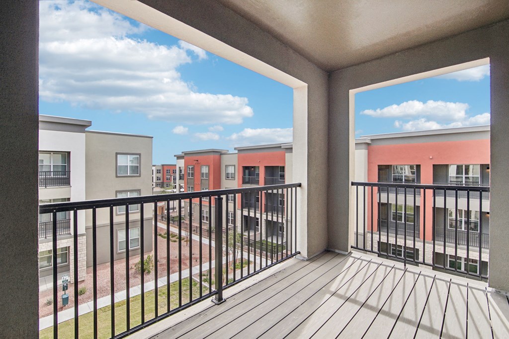 a balcony with a view of a yard and apartment buildings at The Maddox Luxury Apartment Homes, Buckeye, 85326