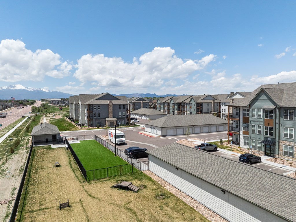 an aerial view of an apartment complex with cars parked in a parking lot