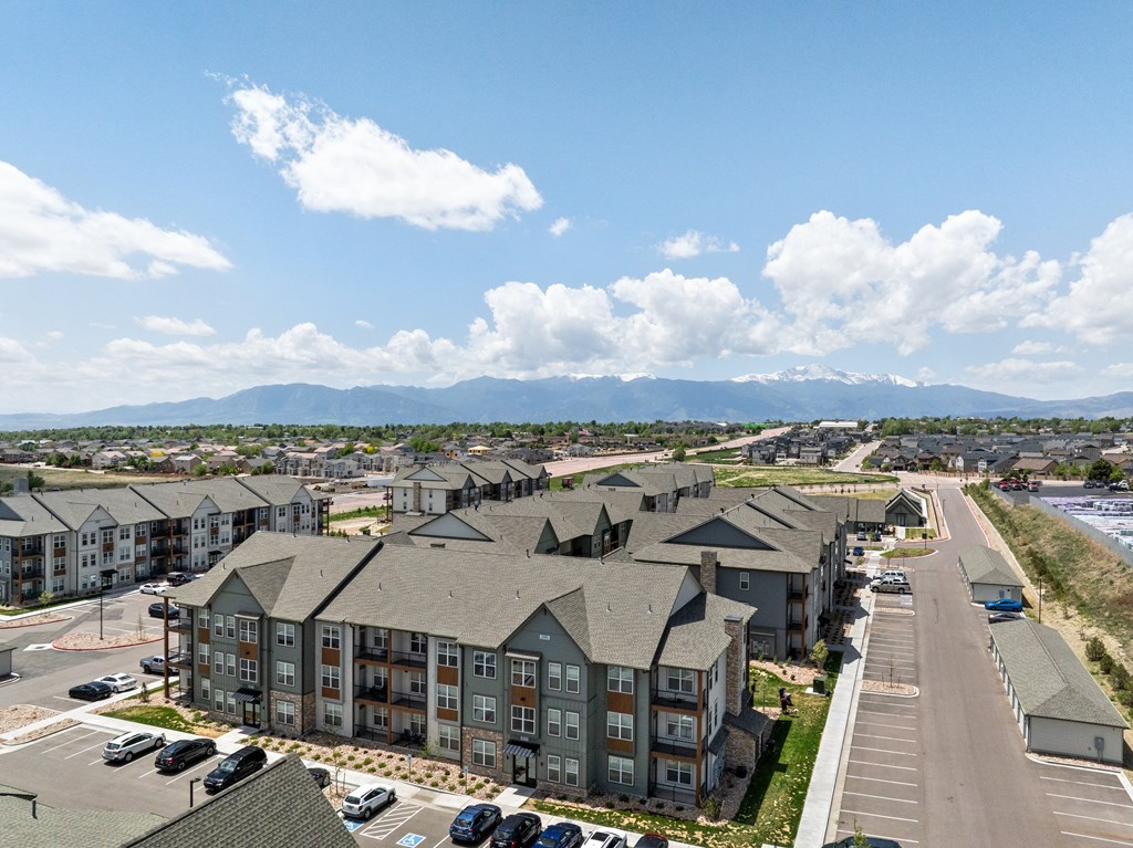 an aerial view of an apartment complex with cars parked in a parking lot
