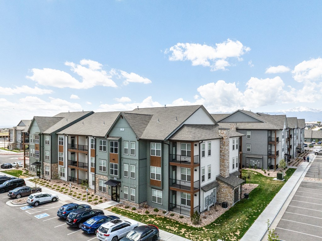 an aerial view of an apartment complex with cars parked in a parking lot