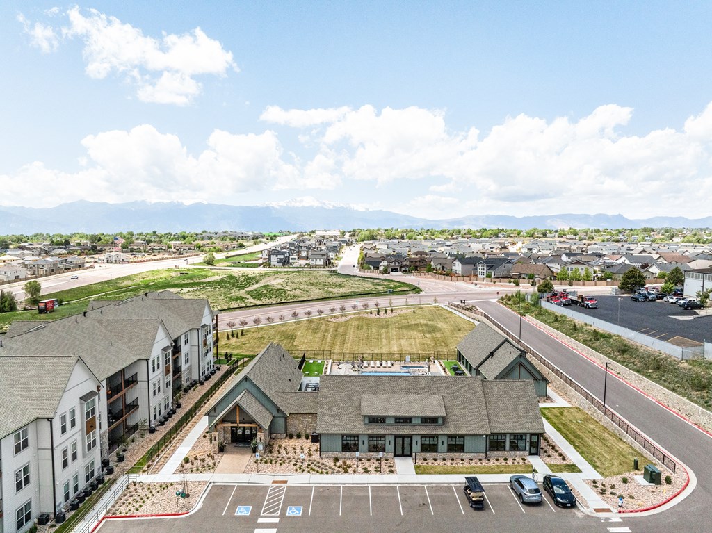 an aerial view of a building with cars parked in a parking lot