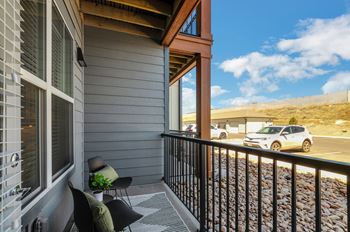 a balcony with a view of a parking lot and a car  at Upland Flats, Colorado Springs, 80922