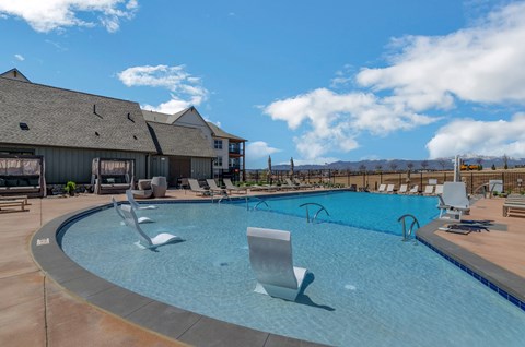 a large swimming pool with lounge chairs and a building in the background  at Upland Flats, Colorado, 80922