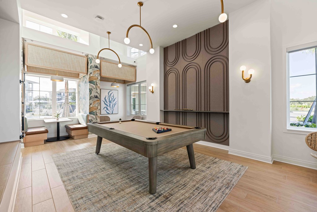 A pool table is in the middle of a room with a brown carpet.