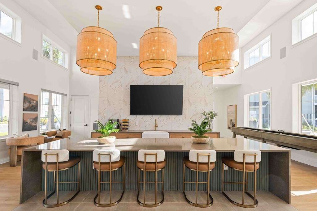 A kitchen with a bar area and a television mounted on the wall.