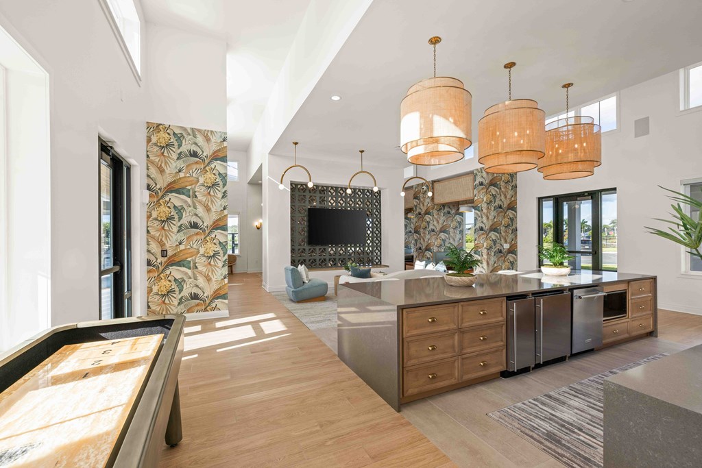 A modern kitchen with a pool table in the middle.
