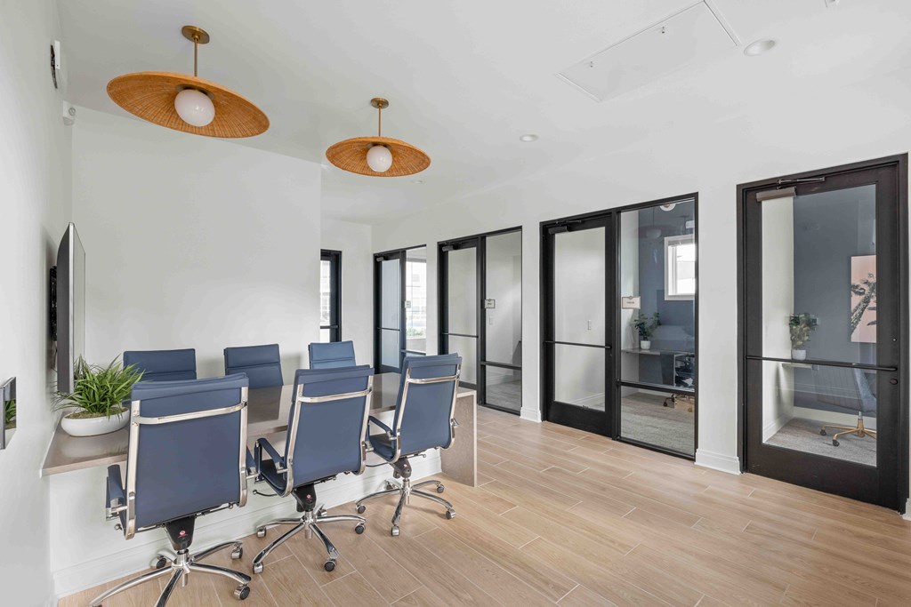 A conference room with blue chairs and wooden floors.
