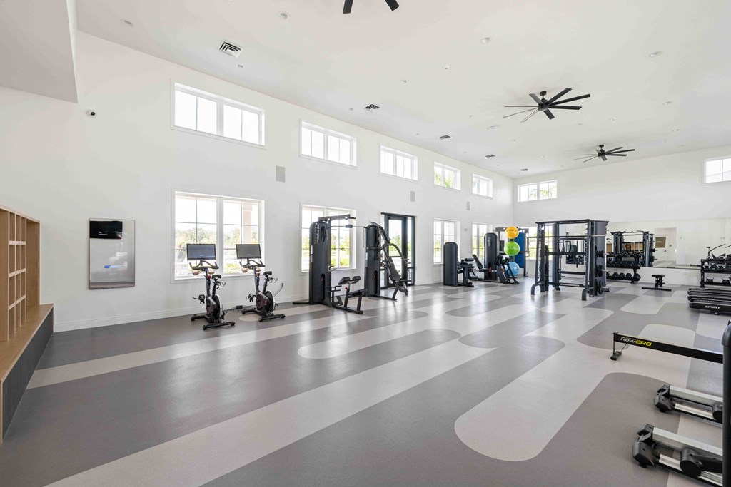 A spacious gym with a variety of equipment and a large mirror on the wall.