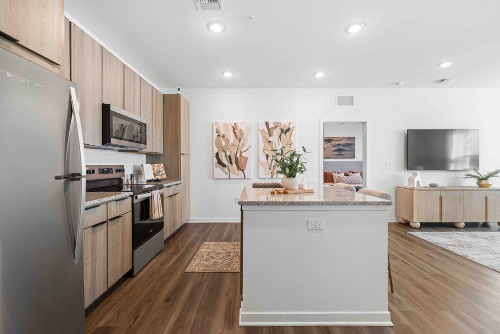 A modern kitchen with wooden cabinets and a large island.