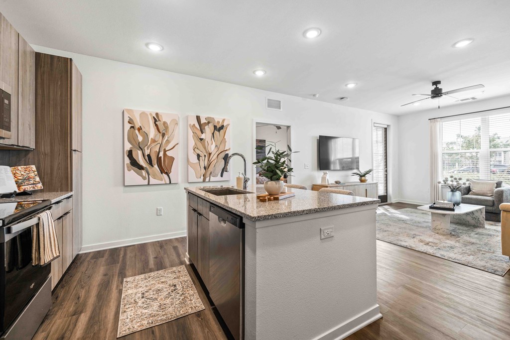 A modern kitchen with a large island and a painting on the wall.