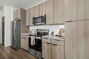 A modern kitchen with wooden cabinets and stainless steel appliances.