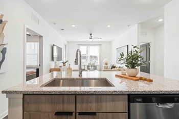 A modern kitchen with a granite countertop and stainless steel appliances.