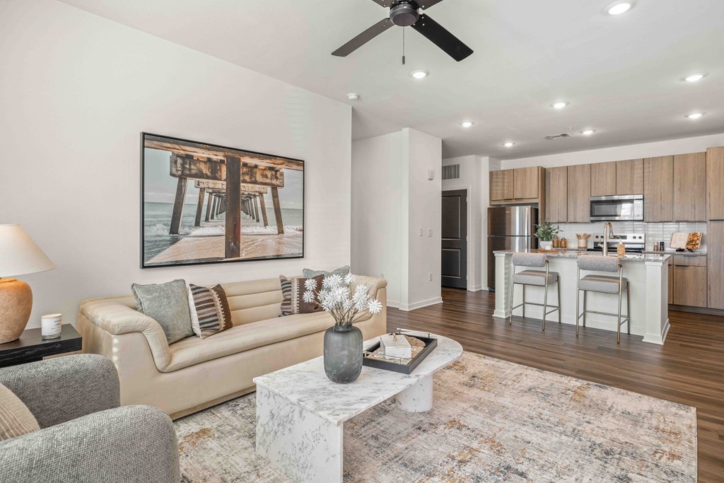 A living room with a couch, a coffee table, and a painting on the wall.