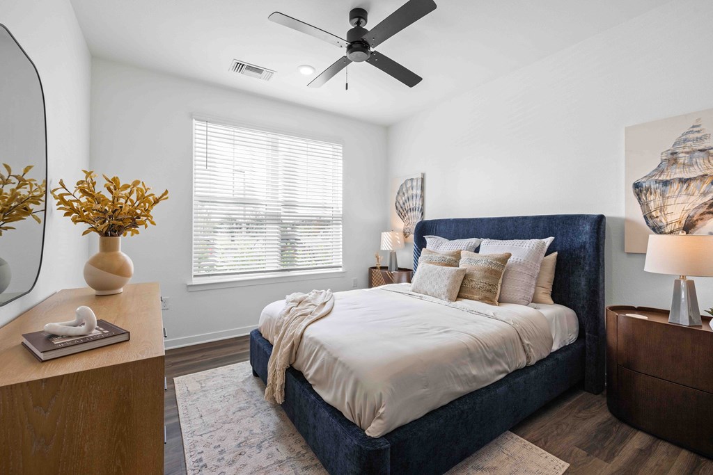 A bedroom with a large bed and a ceiling fan.