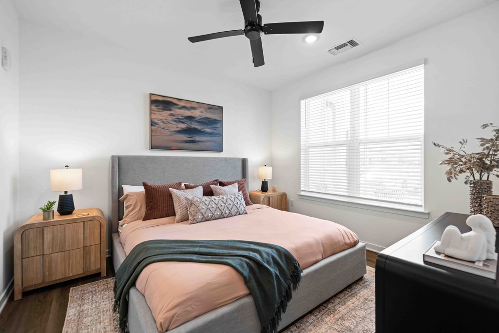 A bedroom with a large bed and a ceiling fan.
