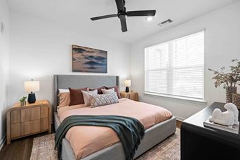 A bedroom with a large bed and a ceiling fan.