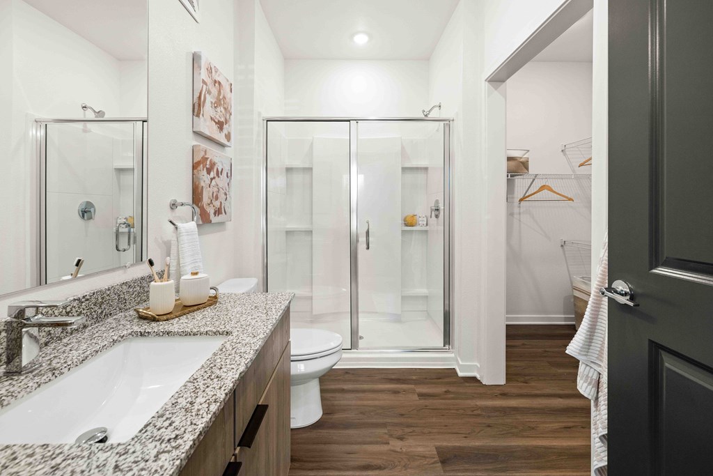 A bathroom with a white sink and a walk-in shower.