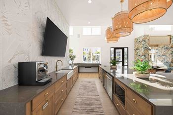 A modern kitchen with a black television mounted on the wall.