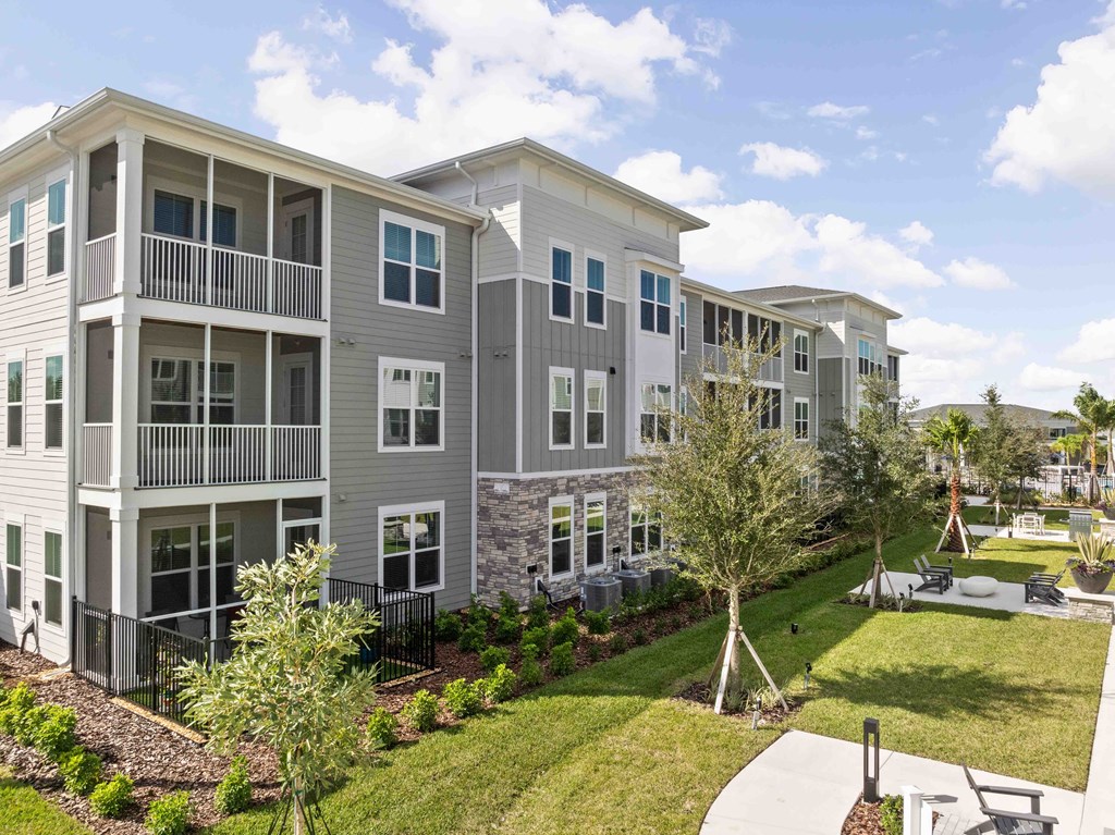 A large apartment complex with a well-maintained lawn and landscaping.